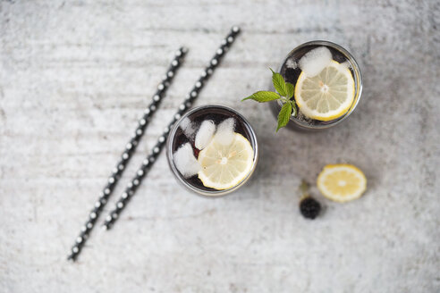 Blackberry limonade with lemon and ice cubes in glasses - MYF001747