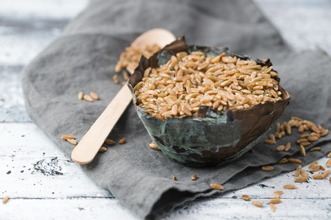 Schüssel mit Kamut, Holzlöffel, lizenzfreies Stockfoto