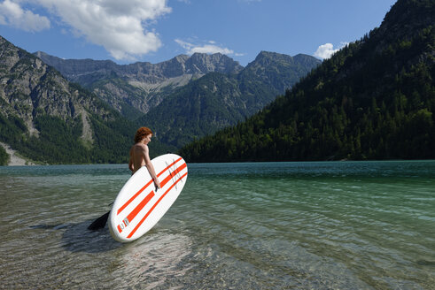 Österreich, Tirol Ammergauer Alpen, Plansee, Jugendlicher mit Paddelbrett - LBF001457