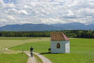 Germany, Bavaria, Faistenberg near Beuerberg, Cyclist at Otthof chapel - LBF001460