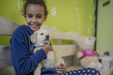 Mädchen hält Labradorwelpe beim Tierarzt - ZEF009822