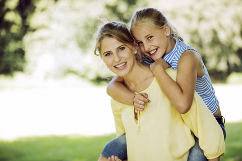 Porträt einer glücklichen jungen Frau und eines Mädchens in einem Park, lizenzfreies Stockfoto