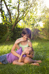 Two sisters playing together on a meadow - LVF005214