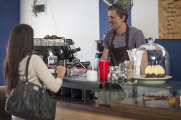 Customer taking an order at coffee shop - ZEF009836