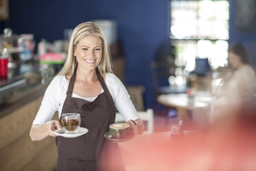Kellnerin serviert Kaffee und Tee in einem Café - ZEF009857