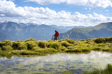 Frau beim Wandern in den Alpen, mit Blick auf die Aussicht - MKFF000326