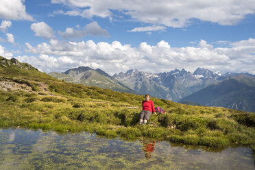 Frau beim Wandern in den Alpen, rastend am See - MKFF000327
