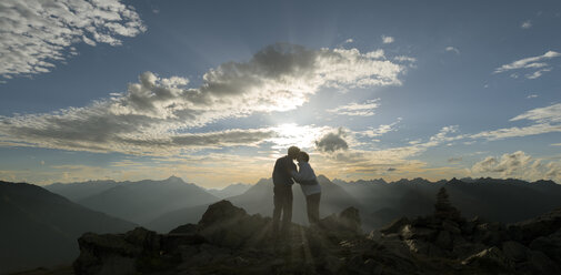 Happy couple kissing at sunset in the mountains - MKFF000331