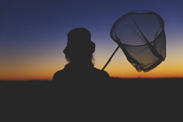 Female hiker carrying dip net at dawn - MIDF000786