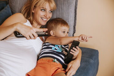 Schwangere Mutter und ihr kleiner Sohn liegen auf der Couch und sehen fern - ZEDF000284