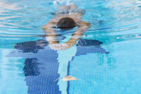 Mann schwimmt im Pool, lizenzfreies Stockfoto