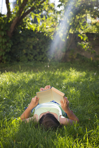 Girl reading book on a meadow stock photo