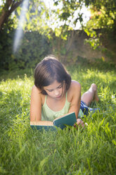 Mädchen liest Buch auf einer Wiese - LVF005230