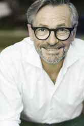 Portrait of smiling man with grey hair and beard wearing spectacles - SBOF000205