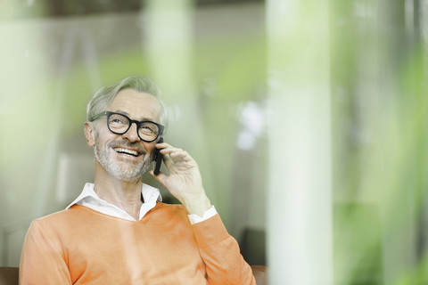 Man on the phone looking through window stock photo