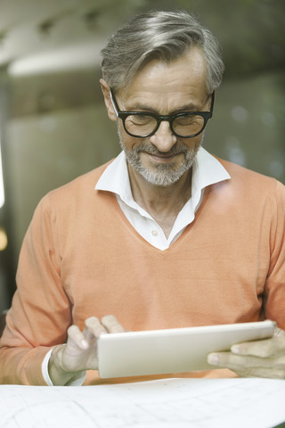 Mann mit Bauplan auf einem Tablet, lizenzfreies Stockfoto