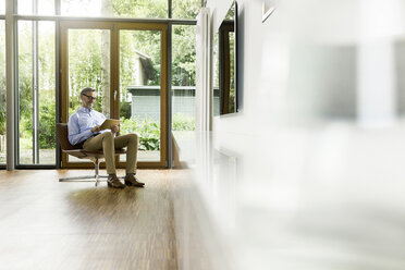 Senior man looking out of window in a loft flat stock photo