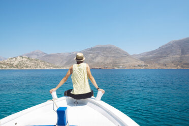 Griechenland, Rückenansicht eines Mannes, der auf dem Bug eines Bootes sitzt und auf die Insel Amorgos blickt - GEMF000990