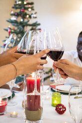 Freunde stoßen bei einem Weihnachtsessen mit Wein an - ABZF001064