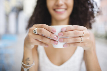 Hände einer jungen Frau halten eine Tasse Kaffee, Nahaufnahme - MRAF000145