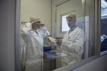 Zwei Laboranten beim Anlegen steriler Schutzkleidung - ZEF010018