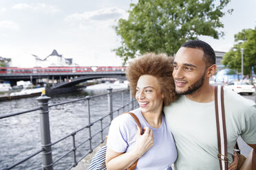 Happy young couple walking by river - FKF002055