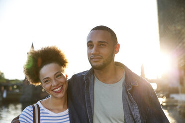 Happy young couple walking by river - FKF002064