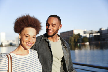 Happy young couple walking by river - FKF002066