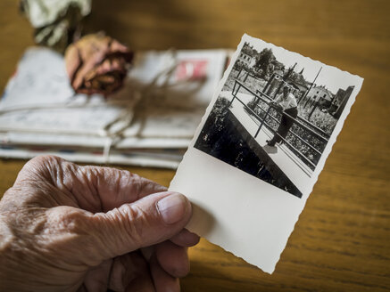 Alte Frau hält Bild ihres Jugendfreundes in der Hand, alte Briefe und getrocknete Rose - EJWF000789