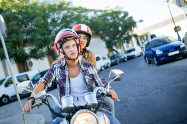 Junges Paar fährt auf einem Motorrad - KIJF000730