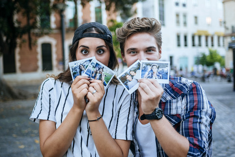 Junges Paar zeigt Fotos von sich selbst, lizenzfreies Stockfoto