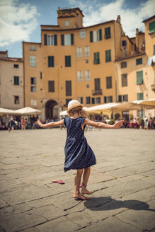 Italien, Lucca, Rückansicht eines tanzenden kleinen Mädchens auf der Piazza dell'Anfiteatro - OPF000134