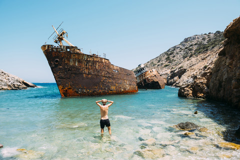 Griechenland, Kykladeninseln, Amorgos, Mann am Strand, Besuch eines Schiffswracks, Olympia, lizenzfreies Stockfoto