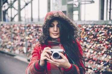 Germany, Cologne, woman with camera at Hohenzollern Bridge - RTBF000283