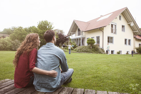 Ehepaar im Garten mit Blick auf das Haus - RBF005078