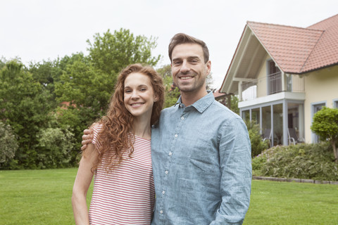 Porträt eines lächelnden Paares im Garten, lizenzfreies Stockfoto