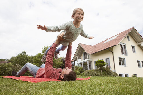 Father playing with daughter in garden - RBF005100