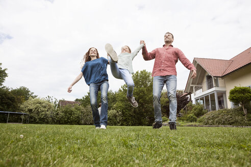 Glückliche Familie beim Spielen im Garten - RBF005103