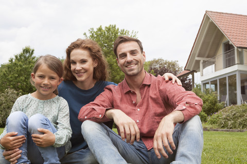 Portrait of smiling family sitting in garden stock photo