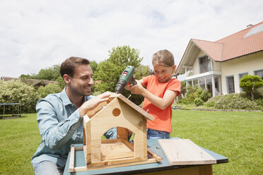 Father and daughter building up a birdhouse - RBF005117