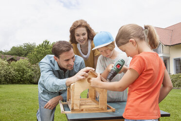 Family building up a birdhouse together - RBF005119