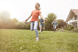 Sorglose Familie beim Laufen im Garten - RBF005122