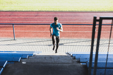 Sportler beim Training auf der Tribüne eines Leichtathletikstadions - UUF008285