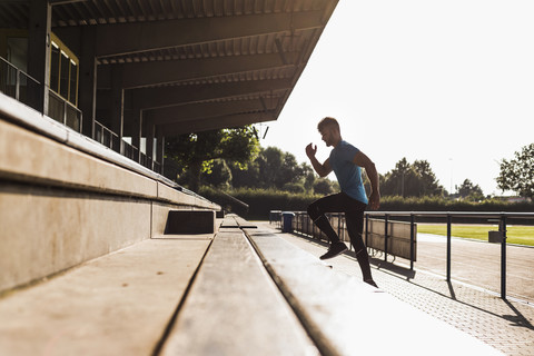 Sportler beim Training auf der Tribüne eines Leichtathletikstadions, lizenzfreies Stockfoto