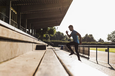 Sportler beim Training auf der Tribüne eines Leichtathletikstadions - UUF008286