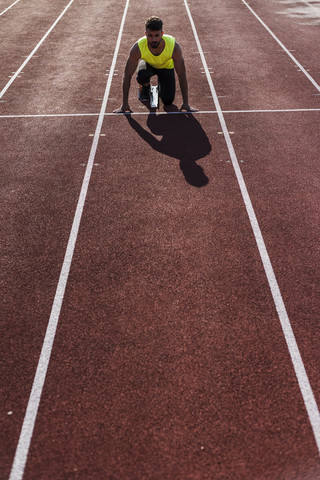 Läufer auf Tartanbahn in Startposition, lizenzfreies Stockfoto