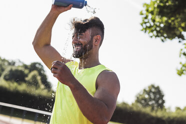 Sportler gießt sich Wasser über den Kopf - UUF008300