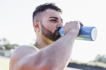 Sportler trinkt aus einer Flasche - UUF008301