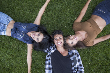Three happy friends lying on meadow, smiling - SIPF000806