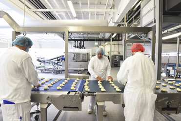 Workers at production line in a baking factory with croissants - LYF000533